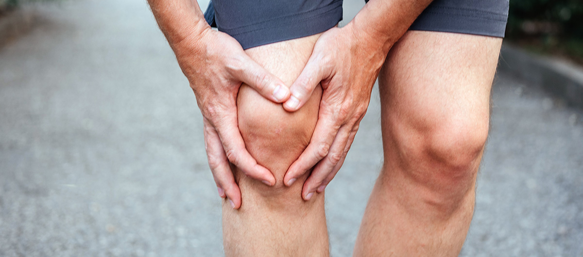 Runner showing signs of knee pain. GMO cookies medical benefits include pain relief.