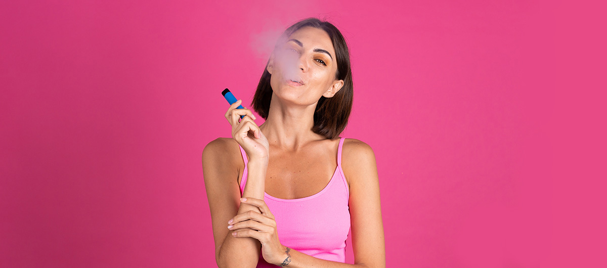Smiling woman using a vape pen in Ajax Ontario. Cannabis dispensary in Ajax & Whitby.