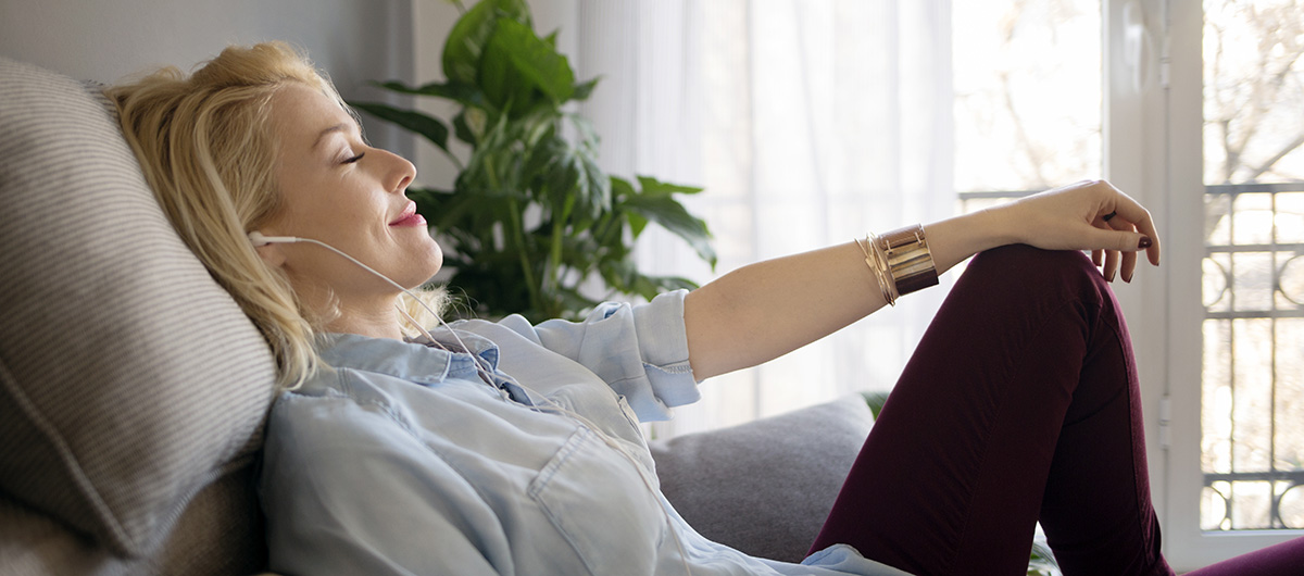 Adult woman smiling and relaxing at home after smoking cannabis GMO cookies strain. Buy weed near me.