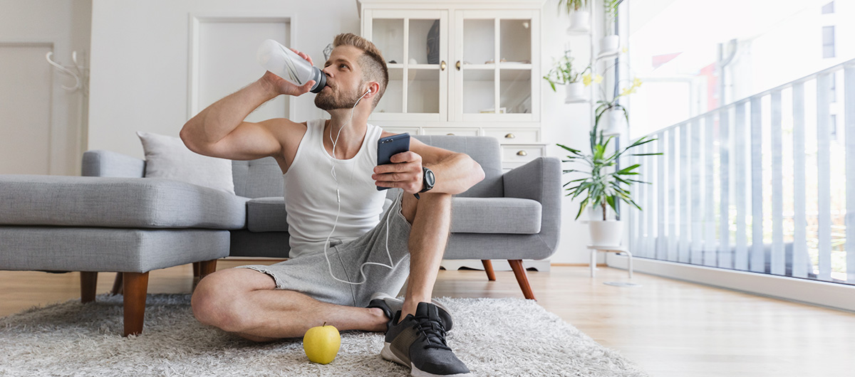 man drinking water from a bottle at home. how long does weed stay in your urine?