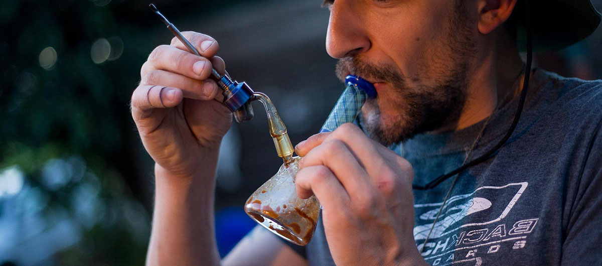 man using a dab rig to smoke cannabis concentrates. dispensary Pickering. dispensary whitby. 
